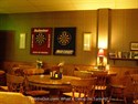 The elevated lounge at Towne Billiards with dart boards and 2 big screen tvs .